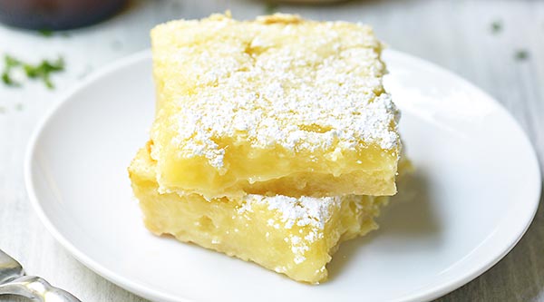 Summer Shandy Lemon Bars! The base is a simple shortbread crust. It’s rich, buttery, and perfectly sweet. The filling is a twist on a classic. It’s light, lemony, and the Summer Shandy comes through beautifully. showmetheyummy.com #summer #shandy #beer #lemon #lemonbars #dessert #shortbread #summershandy