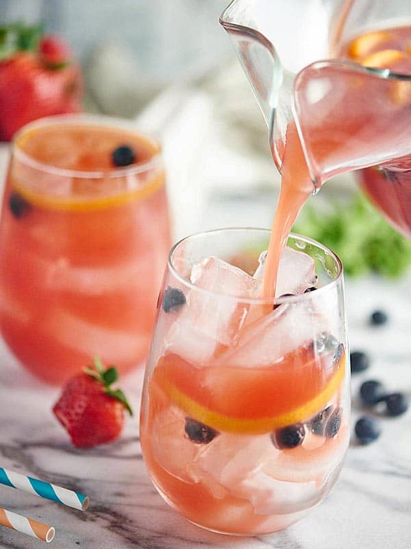 Wassermelonen-Sangria wird mit Eis in Glas gegossen