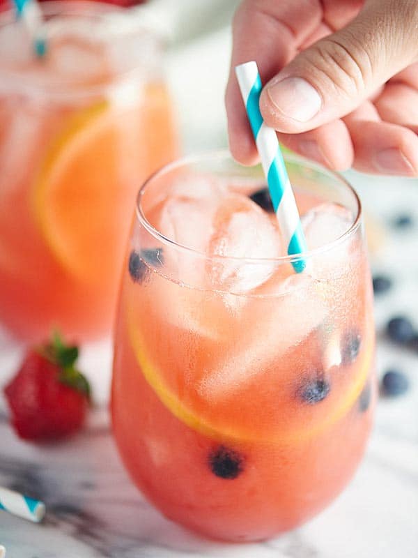 glass of sangria with straw being put in