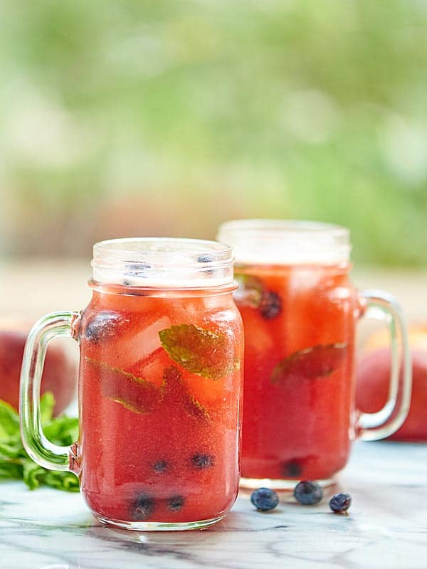 two blueberry peach mojitos