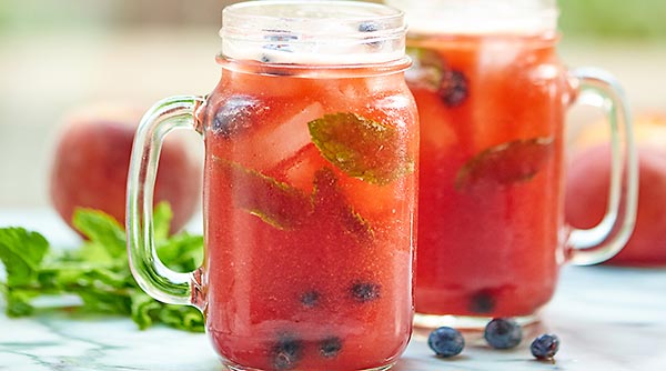 This Blueberry Peach Mojito is the drink of all summer drinks! Peach puree, a homemade blueberry simple syrup, fresh mint, and rum. It's cocktail time! showmetheyummy.com #mojito #cocktail