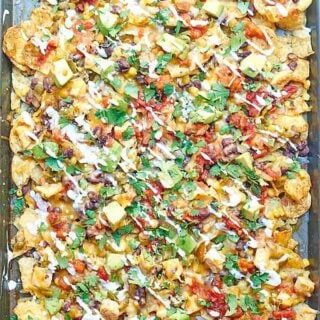 Kettle Chip Chicken Nachos. Jalapeno and Sea Salt Kettle Chips are piled with black beans, chicken, gooey cheese, sweet corn, dollops of sour cream, and some green chiles and jalapeños! showmetheyummy.com #nachos #chicken