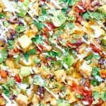 Kettle Chip Chicken Nachos. Jalapeno and Sea Salt Kettle Chips are piled with black beans, chicken, gooey cheese, sweet corn, dollops of sour cream, and some green chiles and jalapeños! showmetheyummy.com #nachos #chicken