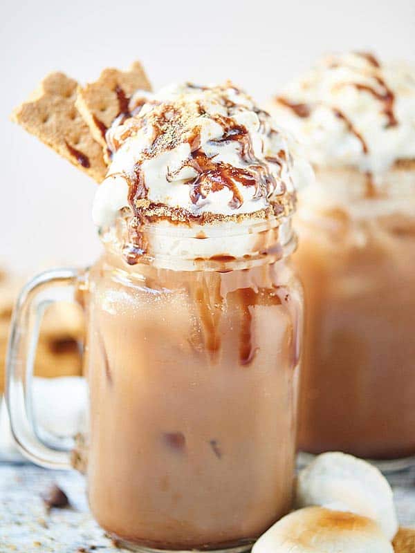 closeup of jar of smores iced coffee garnished with whipped cream and graham crackers