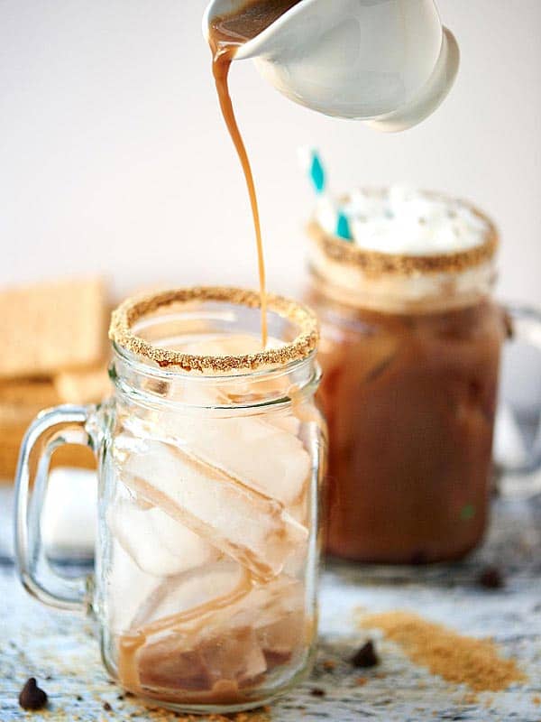 Iced coffee being poured into jar of ice