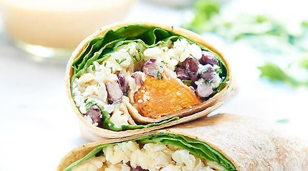 This healthy sweet potato wrap is hearty, vegetarian & full of good for you ingredients like black beans, brown rice & is drizzled in a unique tahini sauce! showmetheyummy.com #wrap #vegetarian