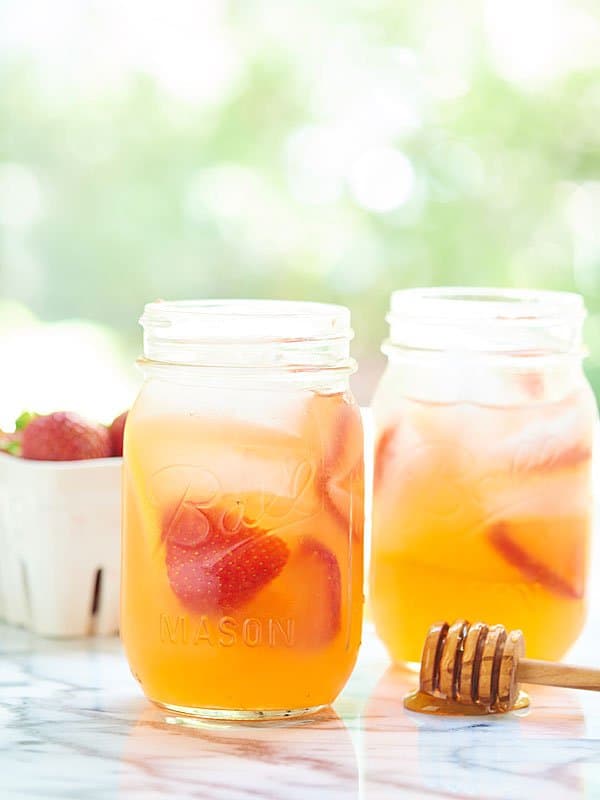 two mason jars of honey strawberry lemonade from the side