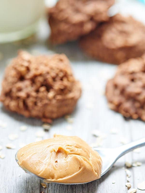 spoonful of peanut butter with cookies in background