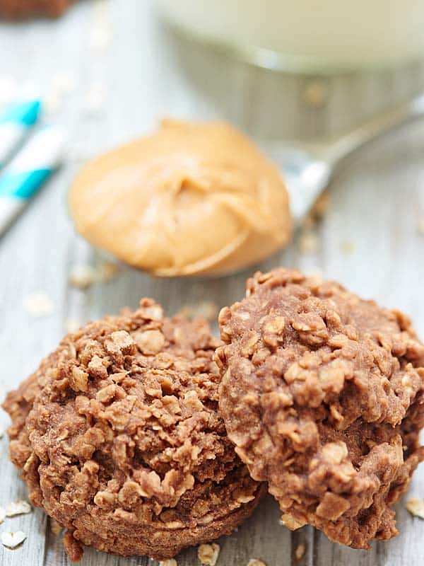 two no bake cookies next to spoonful of peanut butter