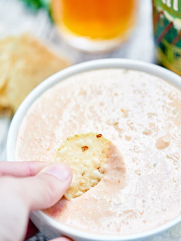 Chip being dipped into cream cheese salsa dip