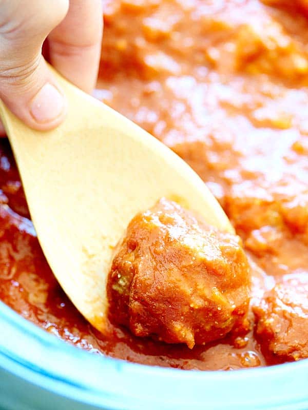 meatball being scooped out of crockpot 