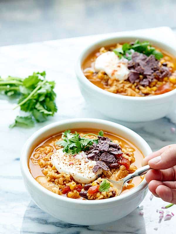 Bowl of chicken and rice soup with spoon being taken out