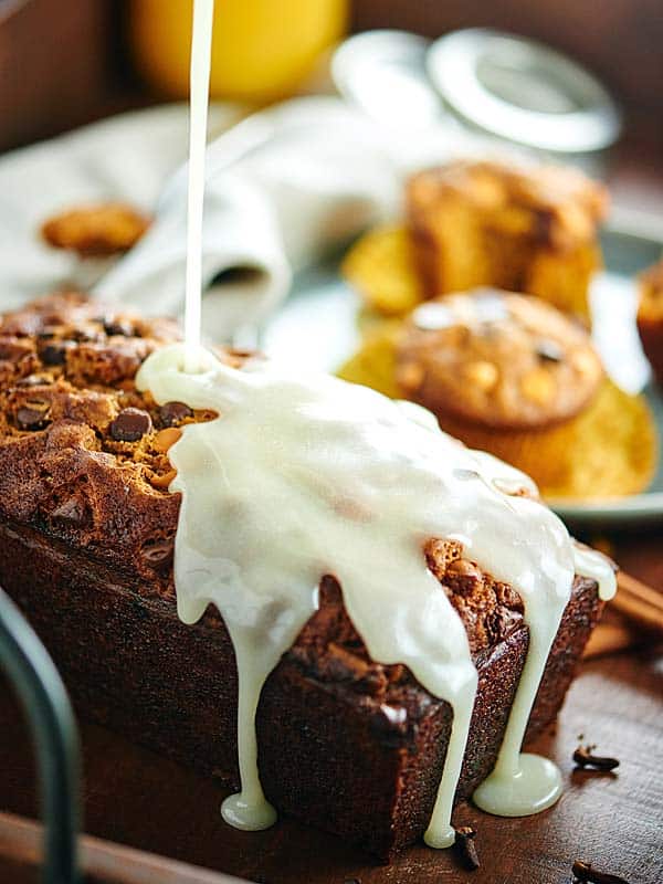 loaf of pumpkin bread being drizzled with icing