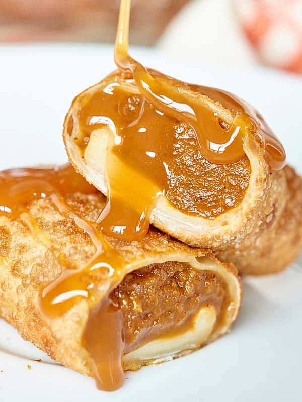 halved pumpkin pie egg roll being drizzled with caramel
