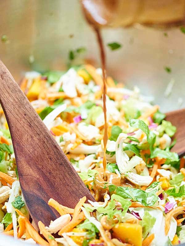 dressing being drizzled into salad