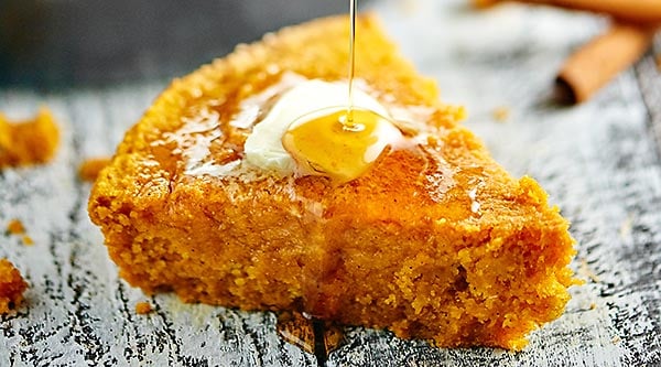 This pumpkin cornbread is a great, easy, vegan side dish for any meal! It's made with whole wheat pastry flour, coconut oil, and smothered in maple syrup! showmetheyummy.com #vegan #pumpkin