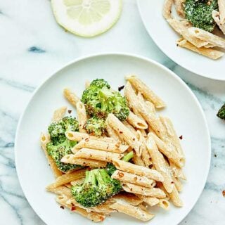 This Vegan Alfredo with Broccoli is made with a healthy cauliflower sauce, roasted broccoli, and whole wheat penne pasta! Cozy, healthy food at it's finest! showmetheyummy.com #pasta #vegan