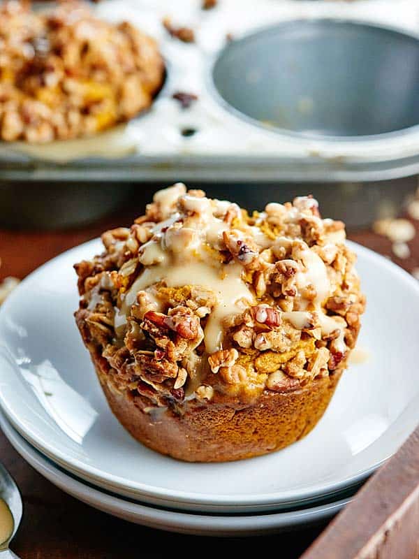 These healthy vegan pumpkin muffins are made w/ whole wheat flour & are naturally sweetened w/ maple syrup! They're topped w/ pecan streusel & maple glaze! showmetheyummy.com #pumpkin #vegan