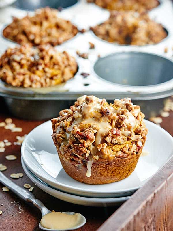Vegan pumpkin muffin on plate muffin tin in background