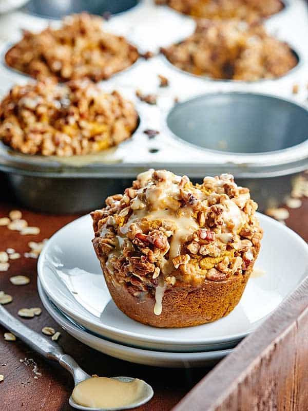 These healthy vegan pumpkin muffins are made w/ whole wheat flour & are naturally sweetened w/ maple syrup! They're topped w/ pecan streusel & maple glaze! showmetheyummy.com #pumpkin #vegan