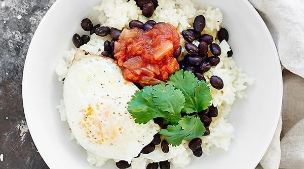 This Cheesy Rice and Beans Recipe is an easy vegetarian, gluten free breakfast or dinner! Black beans & fried eggs makes this dish full of protein! showmetheyummy.com #breakfast #vegetarian