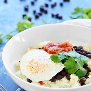 This Cheesy Rice and Beans Recipe is an easy vegetarian, gluten free breakfast or dinner! Black beans & fried eggs makes this dish full of protein! showmetheyummy.com #breakfast #vegetarian