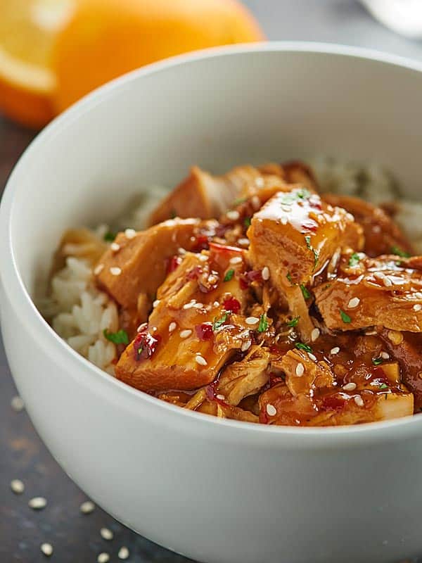 Bowl of orange chicken with rice side view