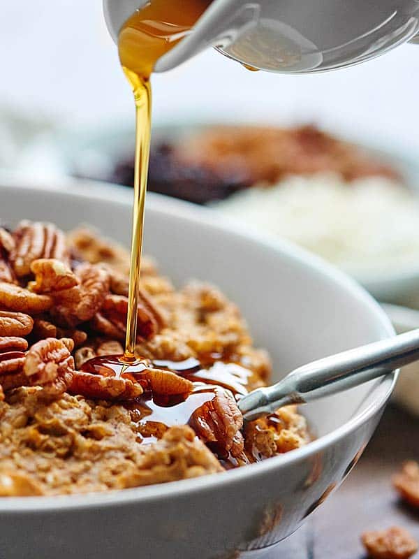 closeup of maple syrup being drizzled on oatmeal