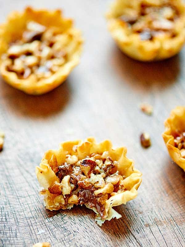 pecan pie bite with bite out, others blurred in background