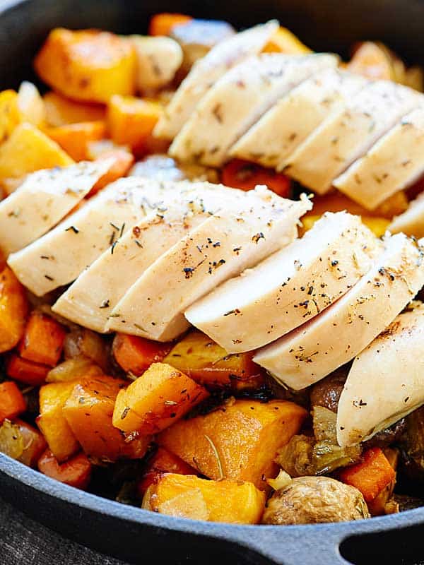 roast veggies in skillet, chicken on top