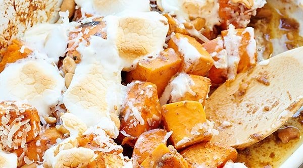 This unique sweet potato casserole is full of roasted sweet potatoes, cashews, coconut, and marshmallows and is smothered in a brown sugar, cinnamon, butter sauce! showmetheyummy.com #thanksgiving #sweetpotatocasserole