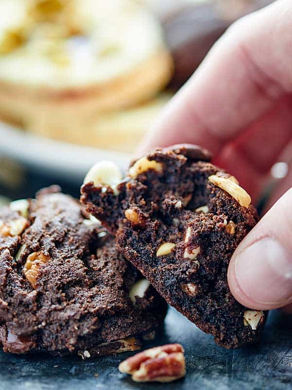 Double chocolate chip cookies on counter, one being picked up