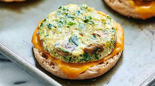 A healthy breakfast sandwich made of eggs, veggies, & optional turkey & cheese! Make these the day of or make them in advance & store in the freezer! showmetheyummy.com #healthy #breakfast