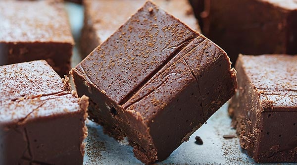This Holiday Chocolate Fudge takes 2 minutes to make in the microwave & is full of egg nog, bourbon, cinnamon, & nutmeg! The easiest holiday candy recipe! showmetheyummy.com #candy #fudge