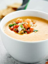 This Easy Queso Dip Recipe is the perfect dip for your chips! It's lightened up with skim evaporated milk and non fat plain greek yogurt, and flavored with cheddar cheese, cumin, chili powder, and fresh pico de gallo! showmetheyummy.com #quesodip #picodegallo #spon #foodshouldtastegood @foodshouldtastegood