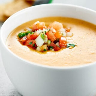 This Easy Queso Dip Recipe is the perfect dip for your chips! It's lightened up with skim evaporated milk and non fat plain greek yogurt, and flavored with cheddar cheese, cumin, chili powder, and fresh pico de gallo! showmetheyummy.com #quesodip #picodegallo #spon #foodshouldtastegood @foodshouldtastegood