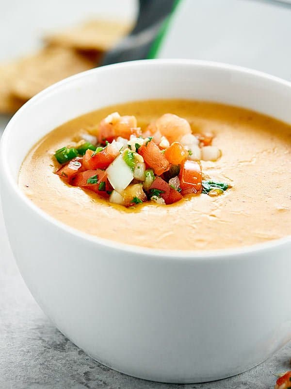 bowl of queso dip with scoop of pico de gallo