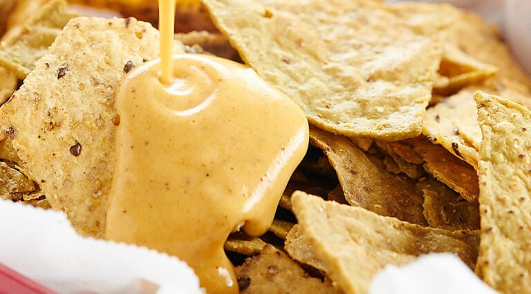 Queso dip drizzled over chips