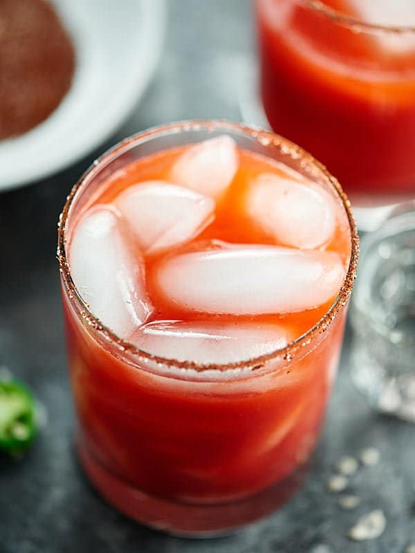 Strawberry jalapeno margarita in a glass with ice above
