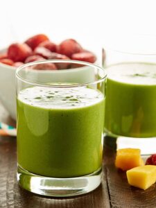 An easy, healthy, tasty tropical green smoothie recipe that's loaded with good for you ingredients like kale, mango, and strawberries! It's gluten free, can be vegan, and only takes 5 minutes to whip up! showmetheyummy.com #greensmoothie #healthy
