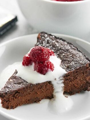 This Vegan Flourless Chocolate Cake Recipe is easy to make, gluten free, & is made w/ better for you ingredients to make a slightly healthier, fudge-y cake! showmetheyummy.com #vegan #flourless #chocolate #cake