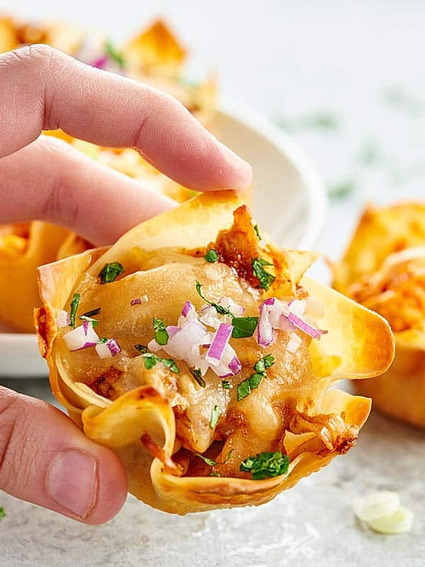 Chicken Wonton Cups made two ways. Wonton cups are filled with a spicy buffalo, blue cheese filling or a sweet BBQ, jack cheese filling and baked to golden perfection! showmetheyummy.com #wontoncups #buffalochicken