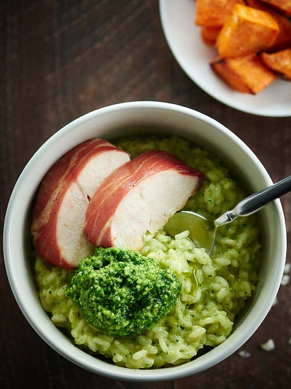 pesto risotto with chicken and veggies in bowl above