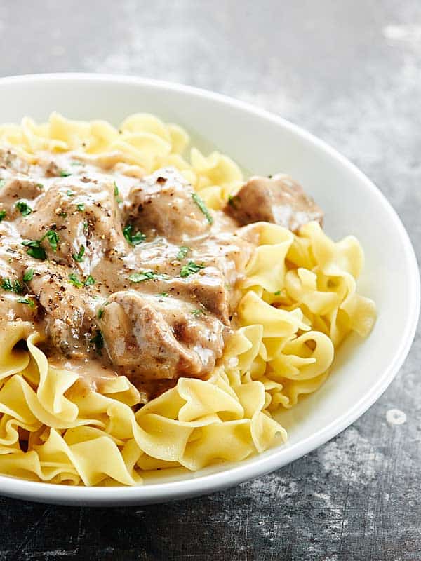 Beef stroganoff on a plate over egg noodles