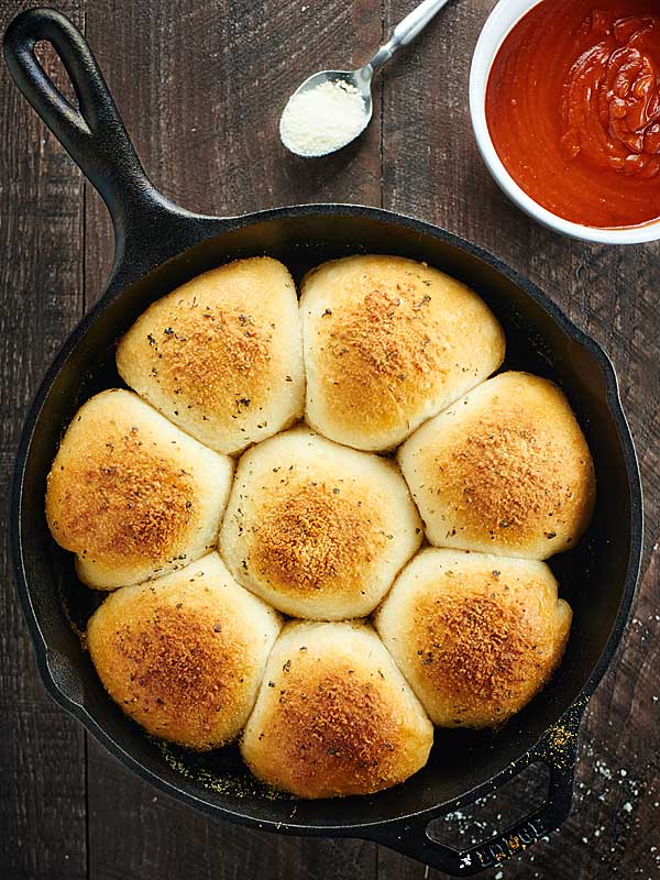 stuffed pizza rolls in skillet pan next to bowl of marinara above