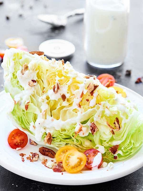 Greek yogurt blue cheese dressing on chunk of lettuce on plate