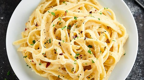 This Healthy Alfredo Sauce is a lightened up version of a classic (530 calories for the ENTIRE recipe). Made with greek yogurt, skim milk, and parmesan! showmetheyummy.com #healthy #alfredosauce