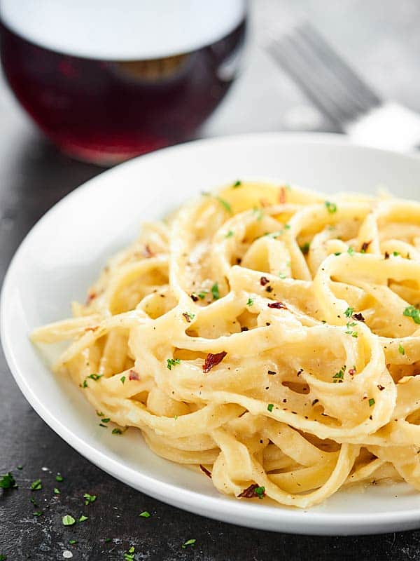 This Healthy Alfredo Sauce is a lightened up version of a classic (530 calories for the ENTIRE recipe). Made with greek yogurt, skim milk, and parmesan! showmetheyummy.com #healthy #alfredosauce