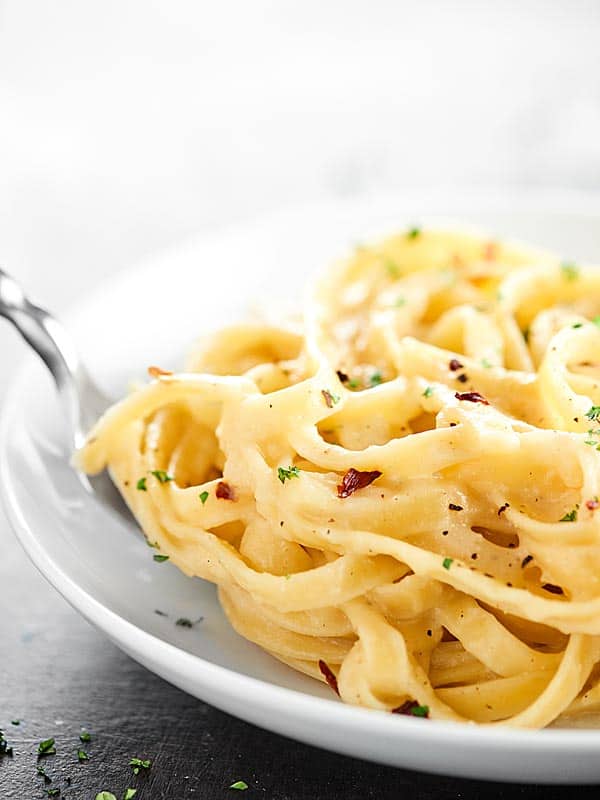 This Healthy Alfredo Sauce is a lightened up version of a classic (530 calories for the ENTIRE recipe). Made with greek yogurt, skim milk, and parmesan! showmetheyummy.com #healthy #alfredosauce