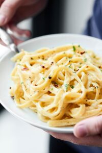 This Healthy Alfredo Sauce is a lightened up version of a classic (130 calories per serving). Made with greek yogurt, skim milk, and parmesan! showmetheyummy.com #healthy #alfredosauce